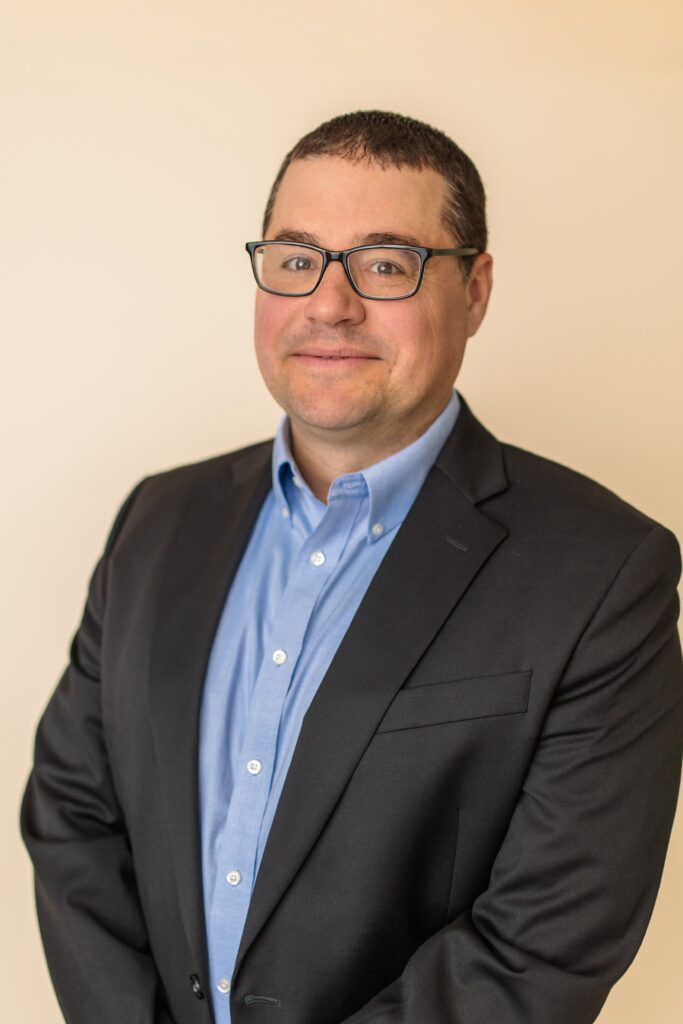 Man in suit with glasses smiling