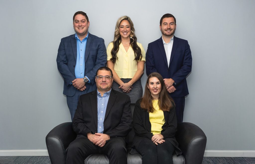 Group of five people posing together